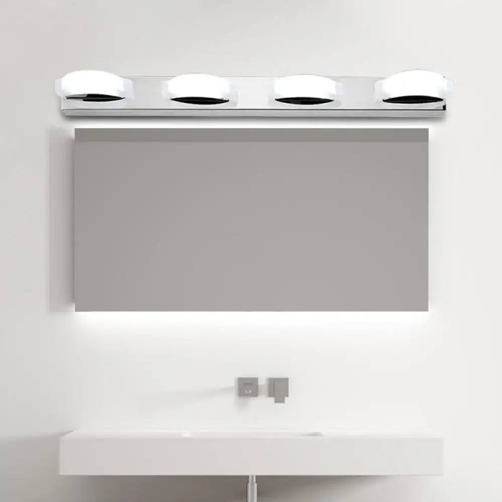 Chrome vanity mirror light with four round bulbs above a modern mirror on Tampa Home & Garden Store