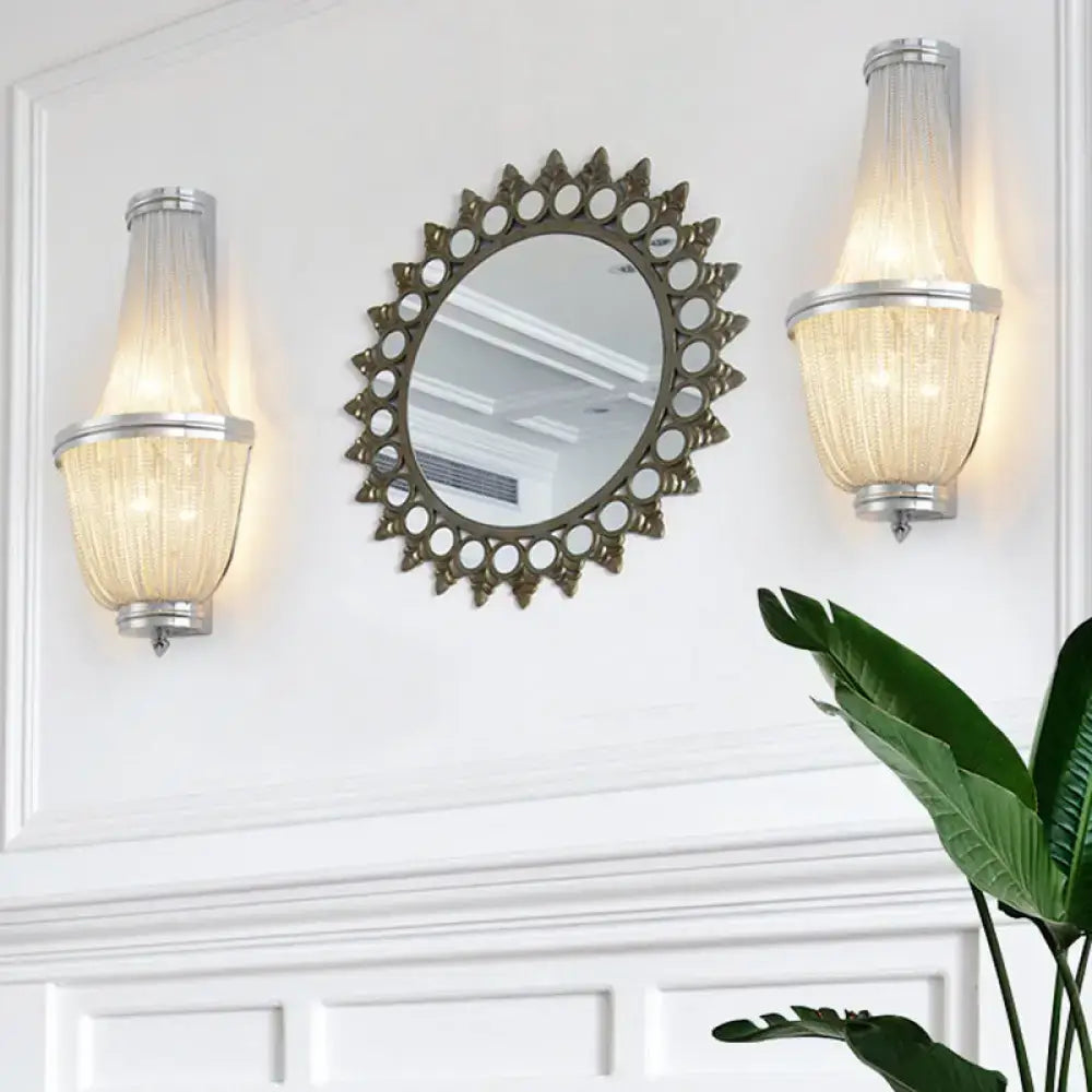 Pair of two-light modern aluminum bedside sconces with ribbed glass shades beside a round mirror on Tampa Home & Garden Store