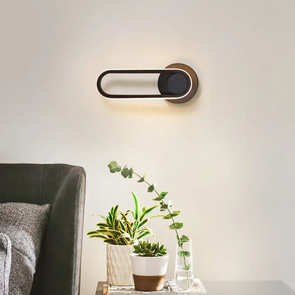 Matte Oval Wall Sconce Decorbites, black oval with circular mount and warm backlight on Tampa Home & Garden Store