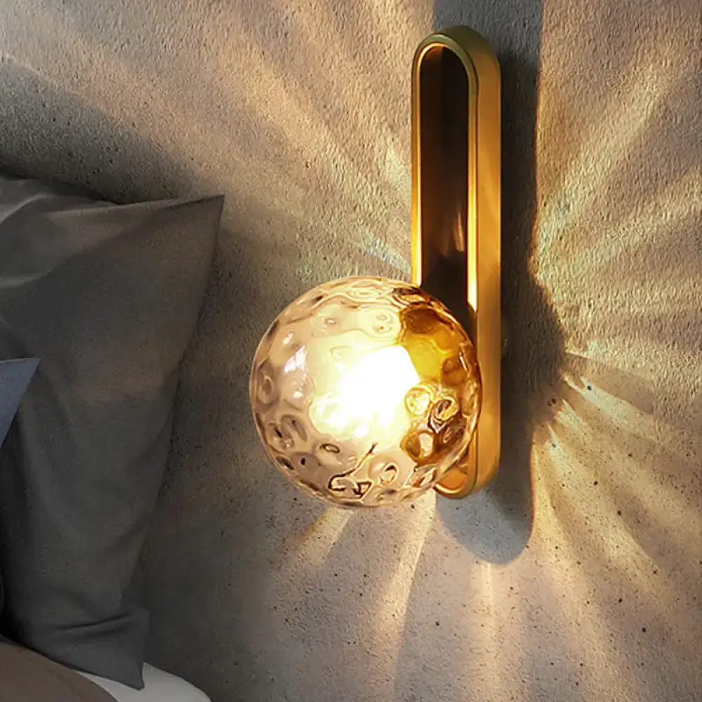 Gold brass wall sconce with a textured glass globe bulb by Decorbites on Tampa Home & Garden Store