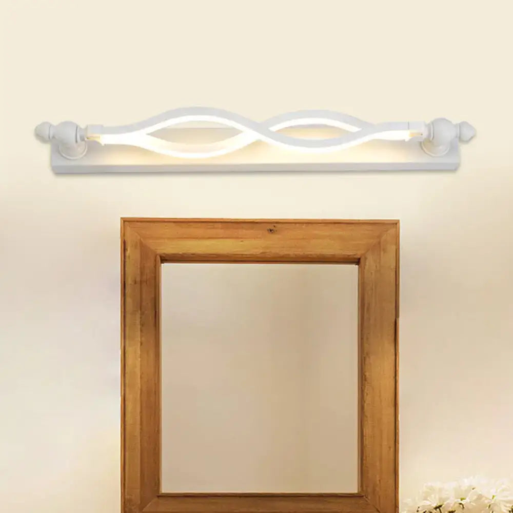 Modern wavy white twist acrylic vanity sconce with warm glow above a wood-framed mirror on wall on Tampa Home & Garden Store