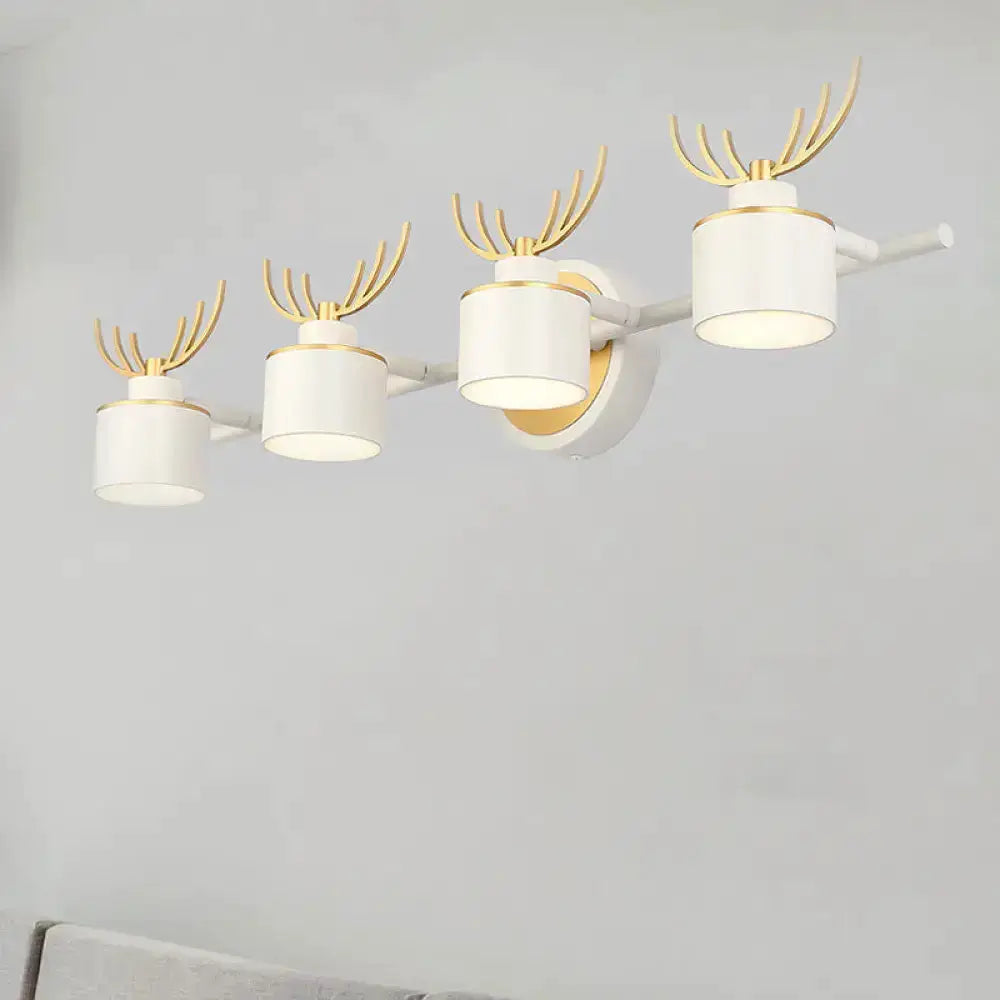 Modern white and gold antler vanity light fixture with four cylindrical LED shades on a wall bar on Tampa Home & Garden Store