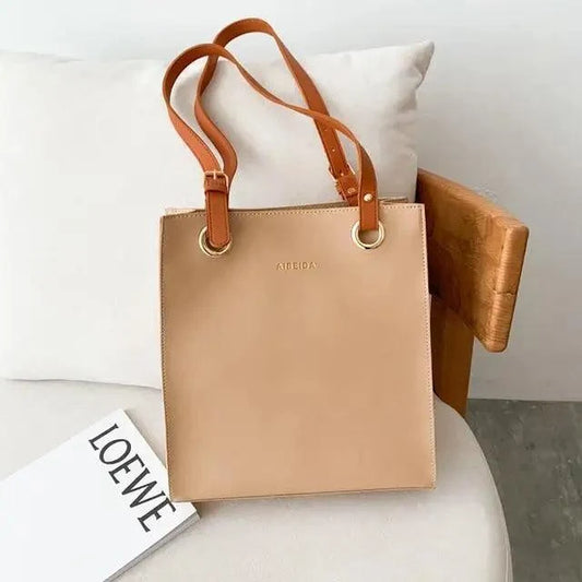 Stevvex tan leather shoulder bag with double straps and gold ring hardware on a chair on Tampa Home & Garden Store