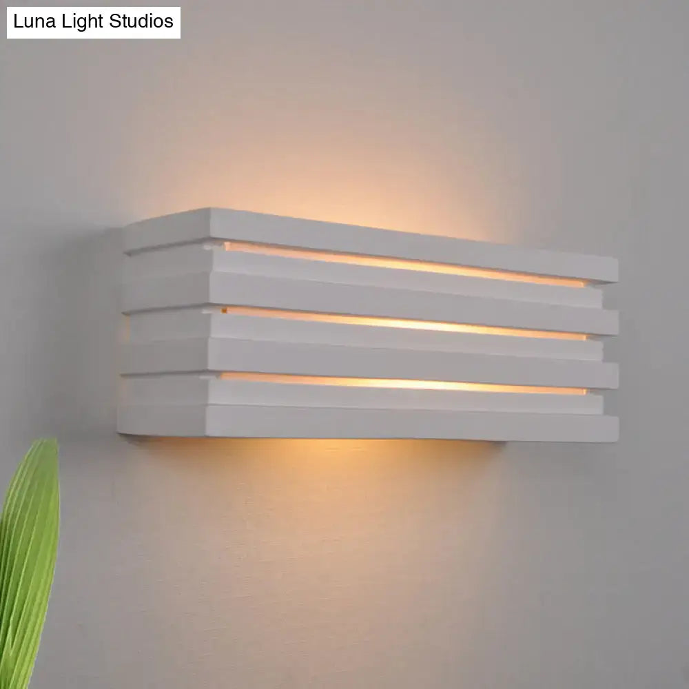 White louvered wall sconce by Decorbites with warm light visible through stacked horizontal slats on Tampa Home & Garden Store