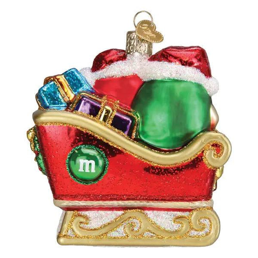 M&M in Sleigh Glass Ornament red sleigh with multicolor gifts and gold base on Tampa Home & Garden Store