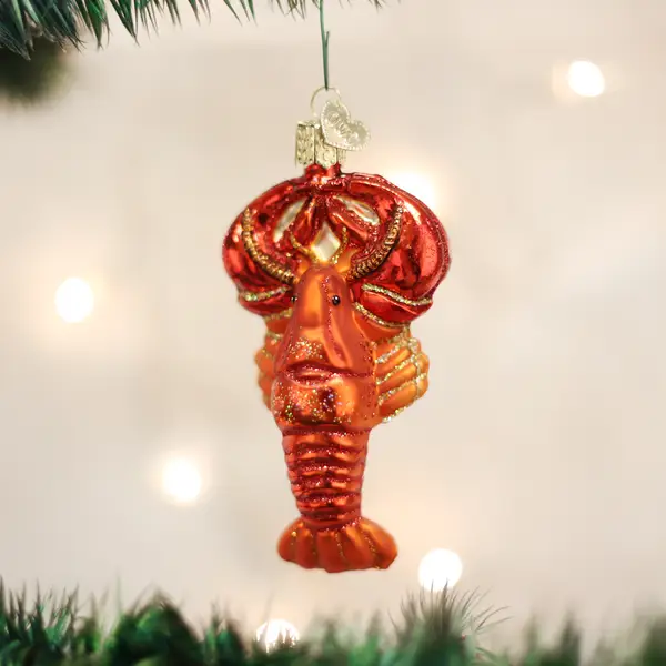 Lobster glass ornament red-orange with subtle gold glitter, hanging from a Christmas tree on Tampa Home & Garden Store