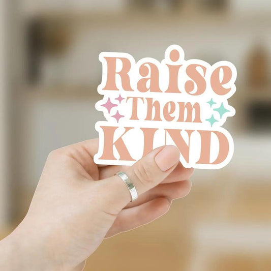 Raise Them Kind sticker with peach lettering and pastel star accents held in hand on Tampa Home & Garden Store