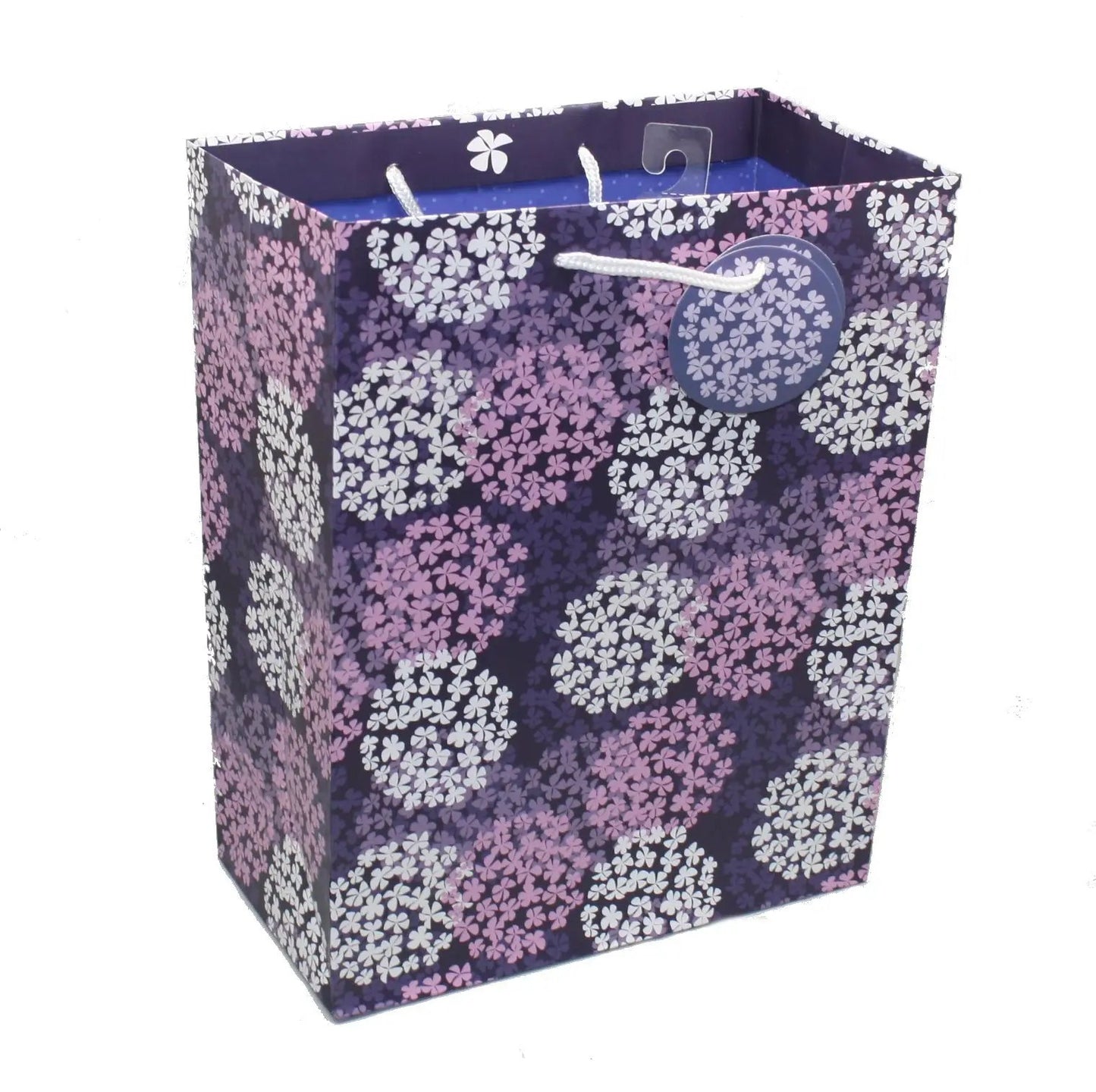 Purple floral gift bag with white rope handles and round glitter tag on Tampa Home & Garden Store