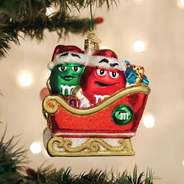 M&M in Sleigh Glass Ornament, red and green M&M characters in a glittery gold sleigh on Tampa Home & Garden Store