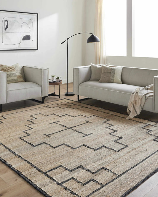 Robyn Handmade Jute Carpet rug in tan and black with a zigzag border in a modern living room on Tampa Home & Garden Store