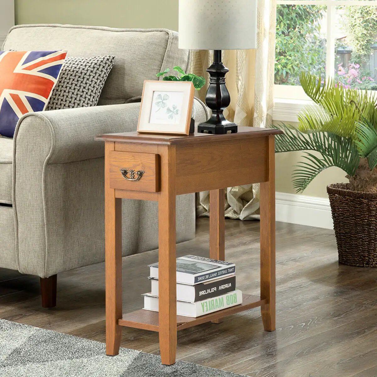 End table with wooden legs, a small drawer and lower shelf in warm oak finish beside a sofa on Tampa Home & Garden Store