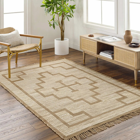 Liana Jute Rug hand woven beige sandstone with fringed edges and border pattern in a sunlit room on Tampa Home & Garden Store