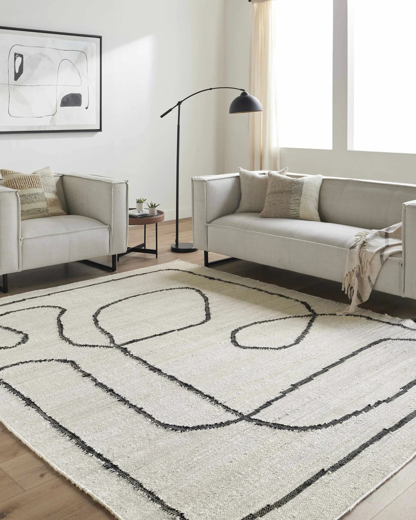 Shael Jute Area Rug, hand woven, cream with black looping pattern, Boutique Rugs in living room on Tampa Home & Garden Store