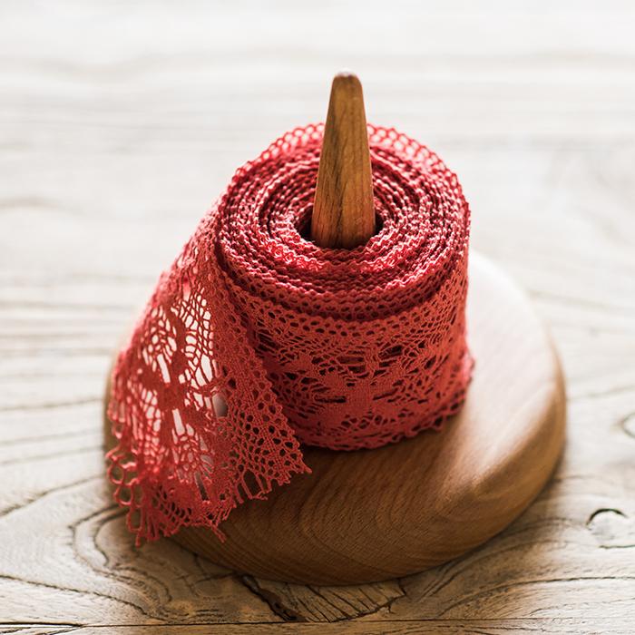 Solid wood paper towel holder with a round base and central spindle holding a red lace roll on Tampa Home & Garden Store