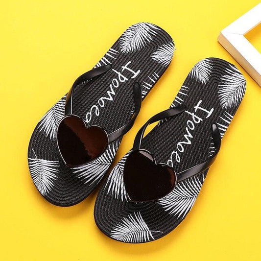 Stevvex women's black palm-leaf flip flops with heart thong strap pair on yellow background on Tampa Home & Garden Store