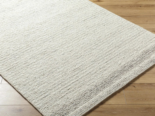 Thady Wool Area Rug hand tufted in ivory charcoal by Boutique Rugs on wood floor on Tampa Home & Garden Store
