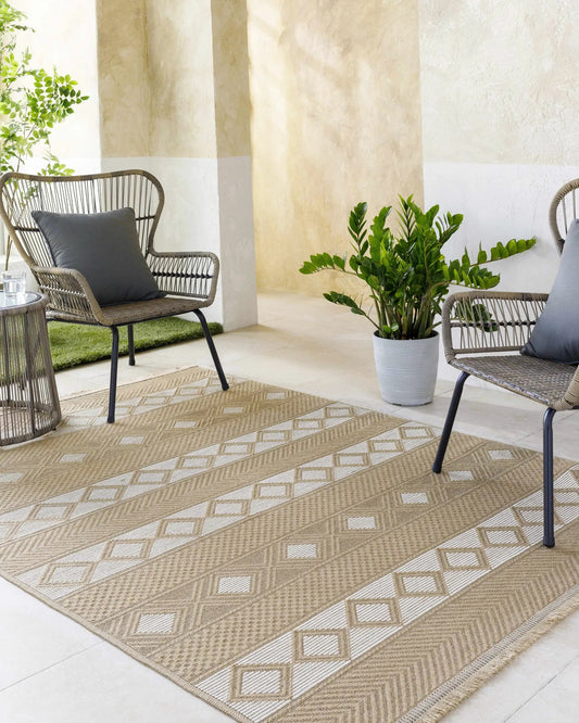 Tomai Washable Jute Rug Tan with Fringe by Boutique Rugs in outdoor seating area with wicker chairs on Tampa Home & Garden Store