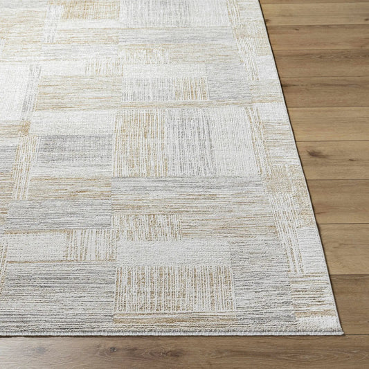 Tamia Luxe Rug machine woven polyester in gray beige patchwork on hardwood floor on Tampa Home & Garden Store
