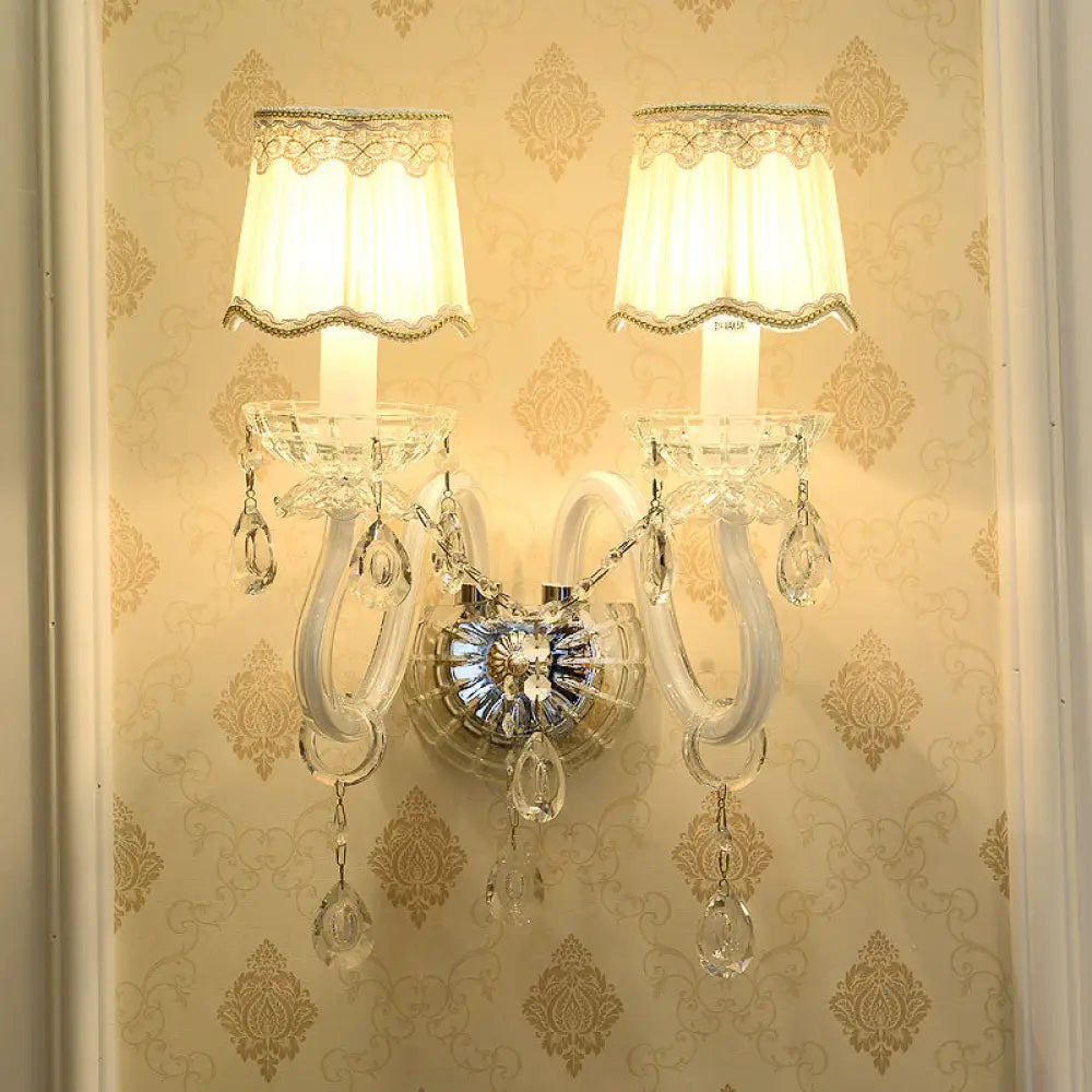 Lámpara de pared tradicional blanca con detalle de cristal transparente y pantalla de tela festoneada