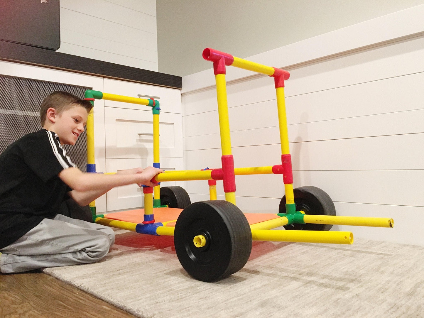 TubeLox Deluxe Set 3x STEM toy with yellow tubes, red connectors, wheels, kid building on Tampa Home & Garden Store