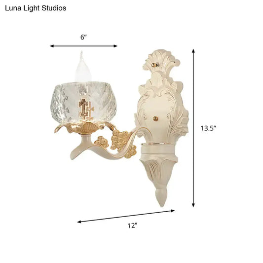 Vintage carved arm wall sconce with clear glass lampshade in cream finish with gold accents on Tampa Home & Garden Store