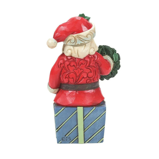 Santa figurine sitting on gifts, hand painted red suit, blue striped box with green wreath on Tampa Home & Garden Store