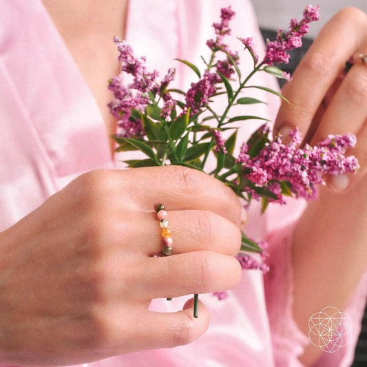 Beaded tourmaline ring by Conscious Items on finger beside pink floral bouquet on Tampa Home & Garden Store