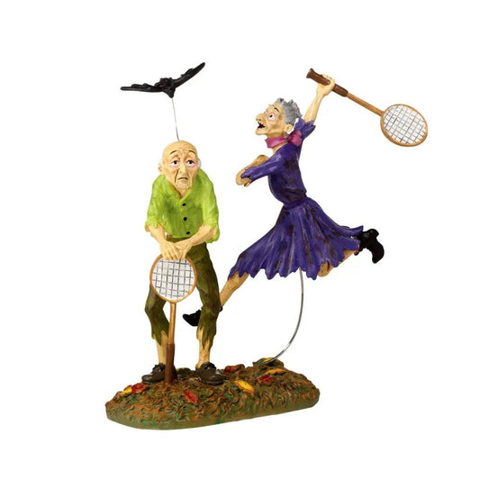 Snow Village Halloween Batminion figurine: elderly man in green and purple woman swinging tennis rackets on grassy base on Tampa Home & Garden Store