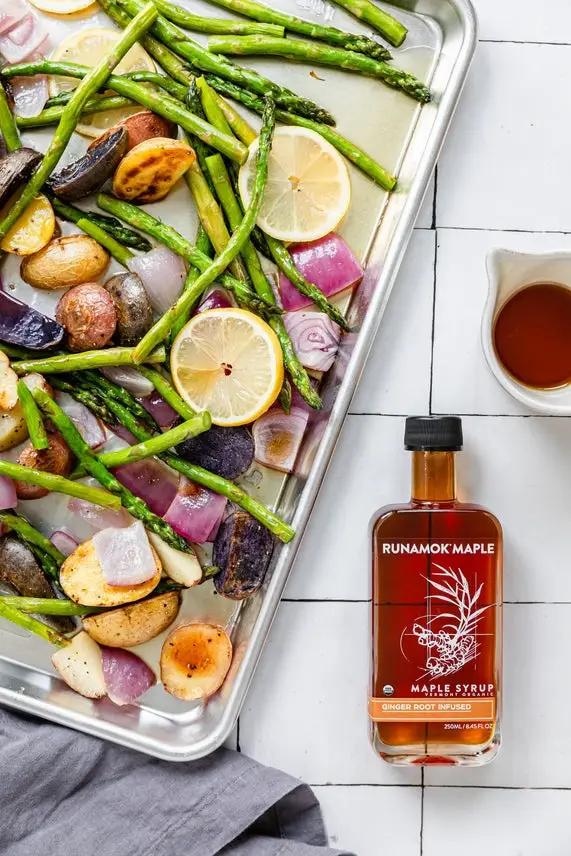 Ginger Root Infused Maple Syrup bottle by Runamok Maple beside roasted veggies with lemon slices on Tampa Home & Garden Store