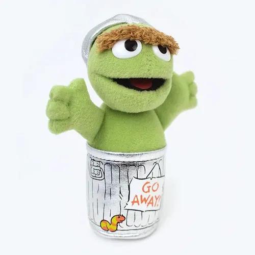 Sesame Street Oscar the Grouch plush beanbag perched on a silver trash can with Go Away sign on Tampa Home & Garden Store