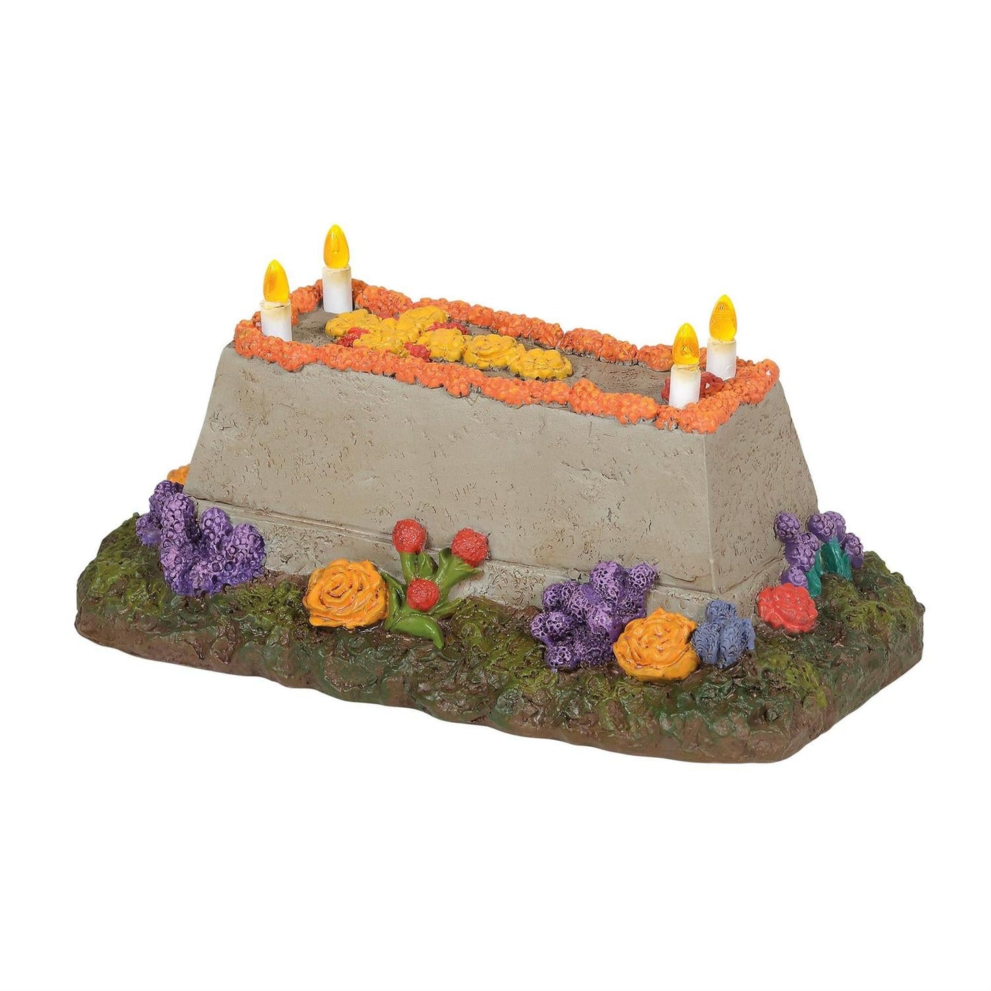 Day of the Dead lit memorial with a gray tomb, orange marigold border, flowers and candles on Tampa Home & Garden Store