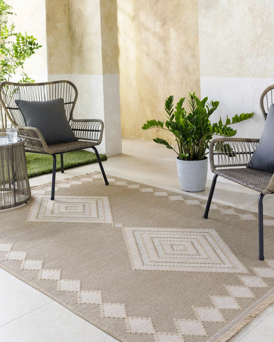 Ziggy washable jute rug tan beige on a patio with wicker chairs and plants Boutique Rugs on Tampa Home & Garden Store