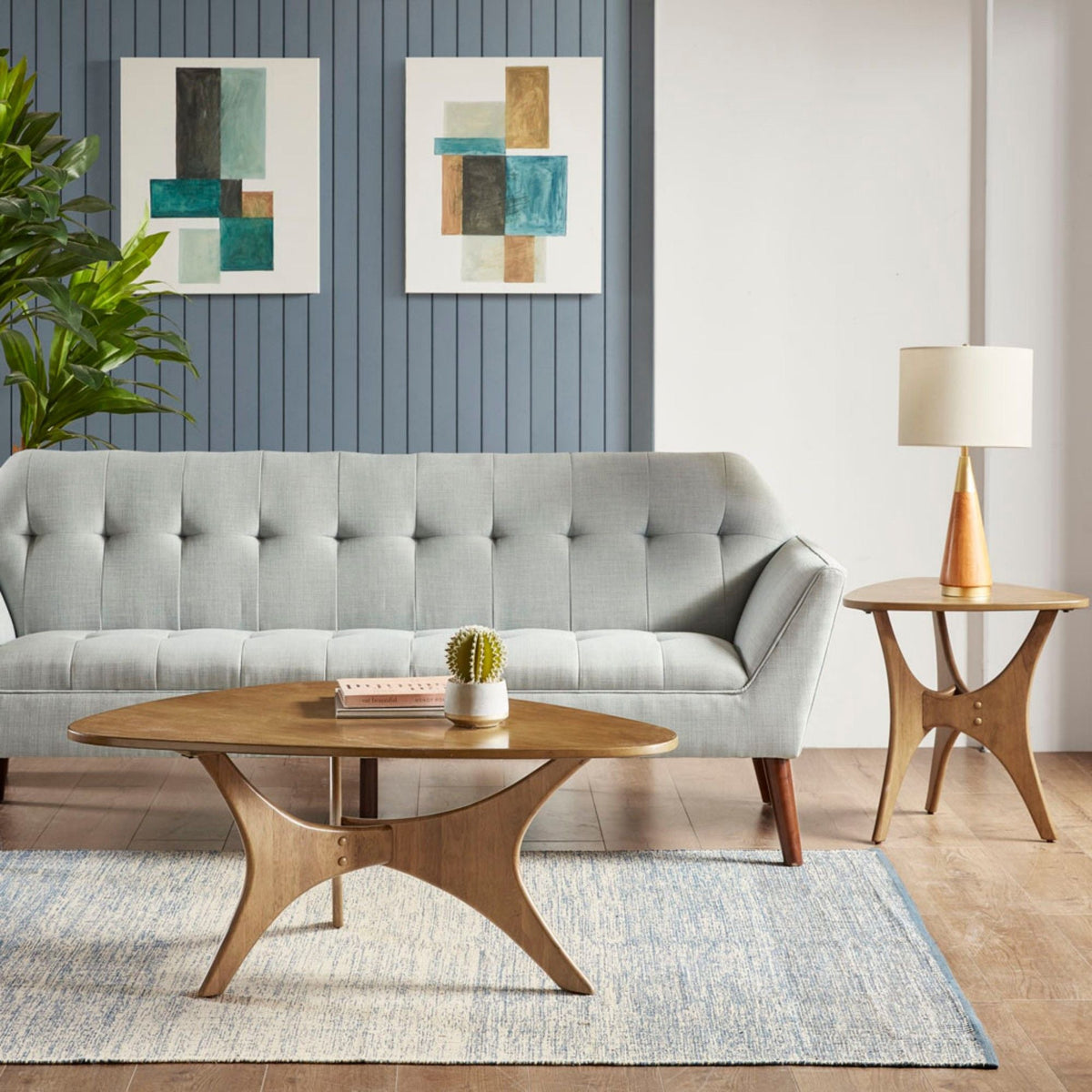 Triangle Wood Veneer Side Table in warm brown finish by HouseOfZazla beside a gray sofa on Tampa Home & Garden Store