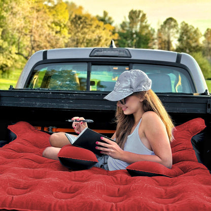 Red 5.5-6.5ft truck bed air mattress by Dikasun Outdoor, laid in a pickup with a woman reading on Tampa Home & Garden Store