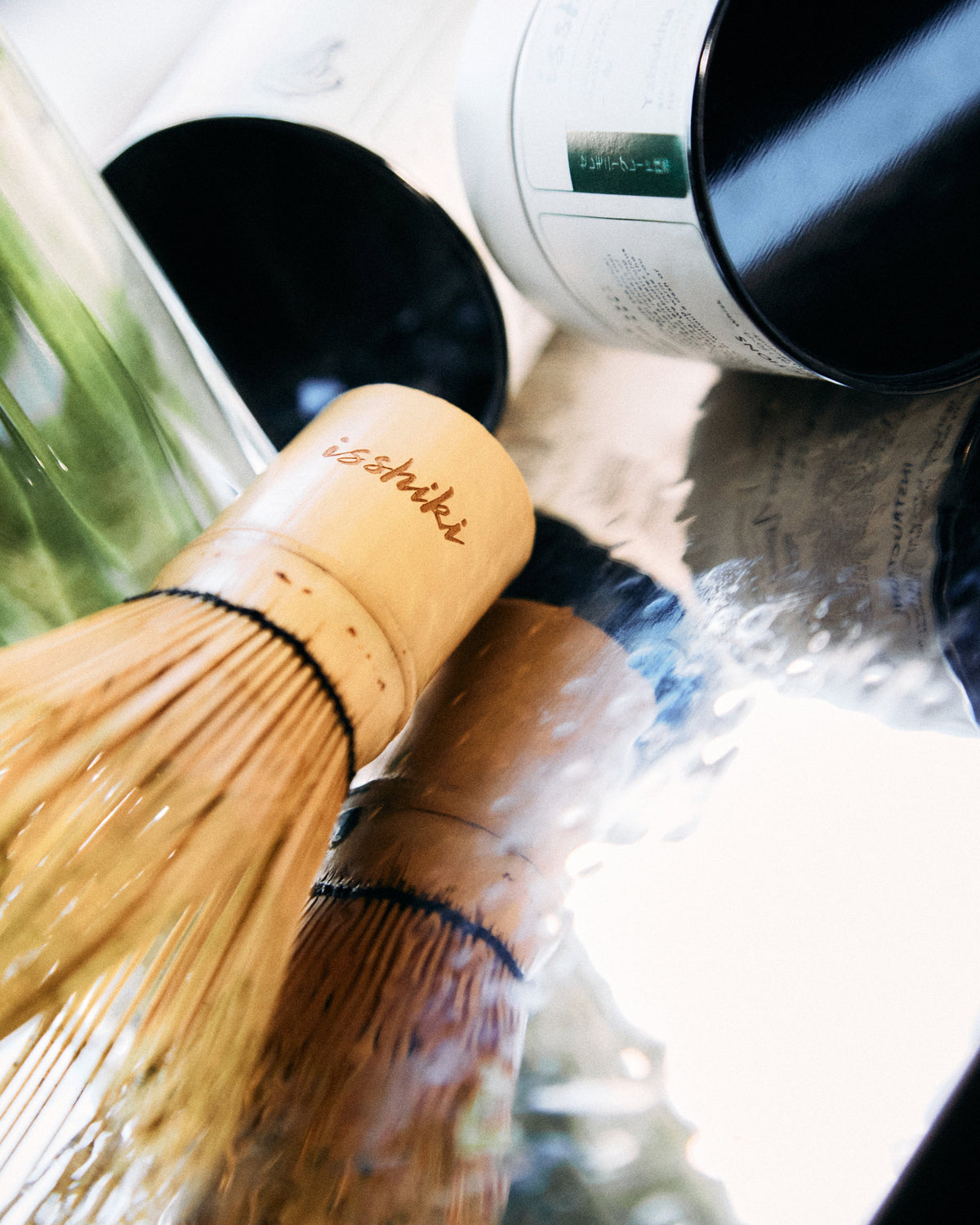 Bamboo matcha whisk (chasen) by isshiki matcha, close-up with background tea bottles on Tampa Home & Garden Store