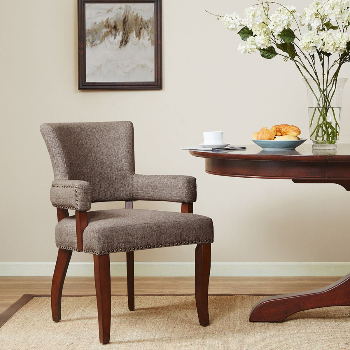 Elegant Arm Dining Chair in gray fabric with brass nailhead detailing and dark wood legs on Tampa Home & Garden Store