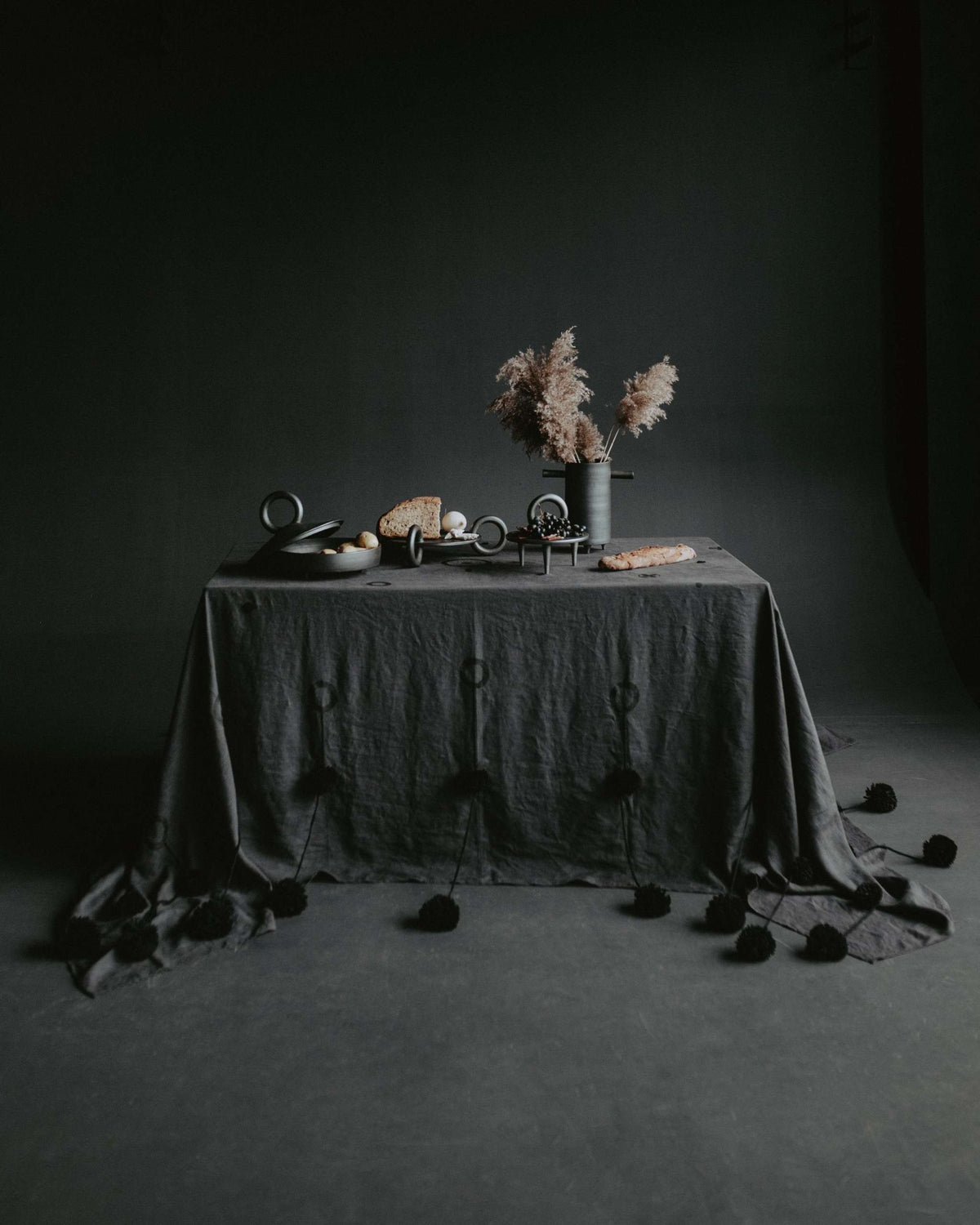 Shallow serving bowl with lid Guculia Shadow in dark ceramic on a moody table with pampas vase on Tampa Home & Garden Store