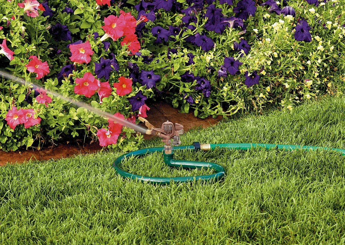 Brass impact sprinkler on metal ring base watering lawn with a green hose Orbit Irrigation on Tampa Home & Garden Store