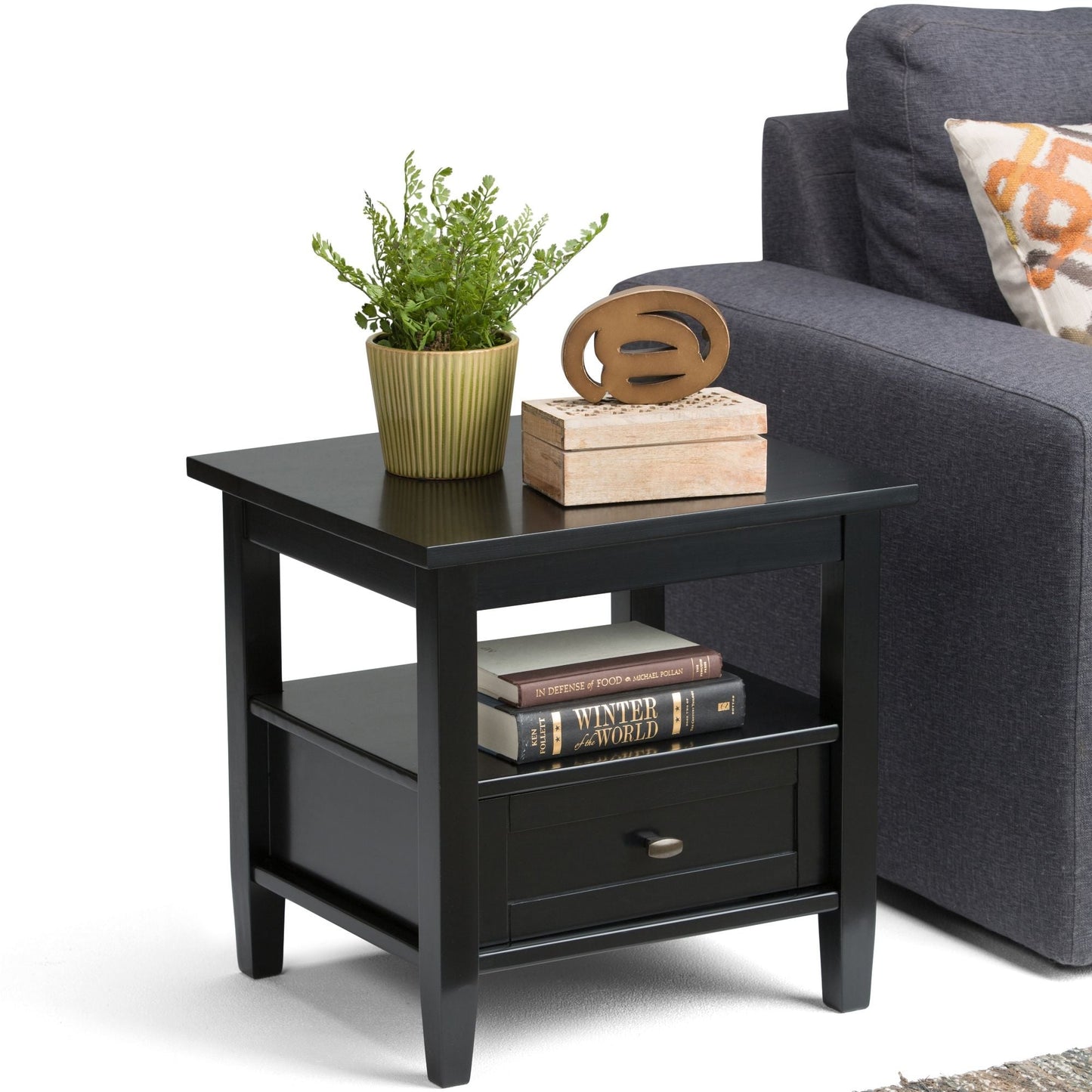 Warm Shaker end table in black with green plant and wooden sculpture on shelf with books on Tampa Home & Garden Store