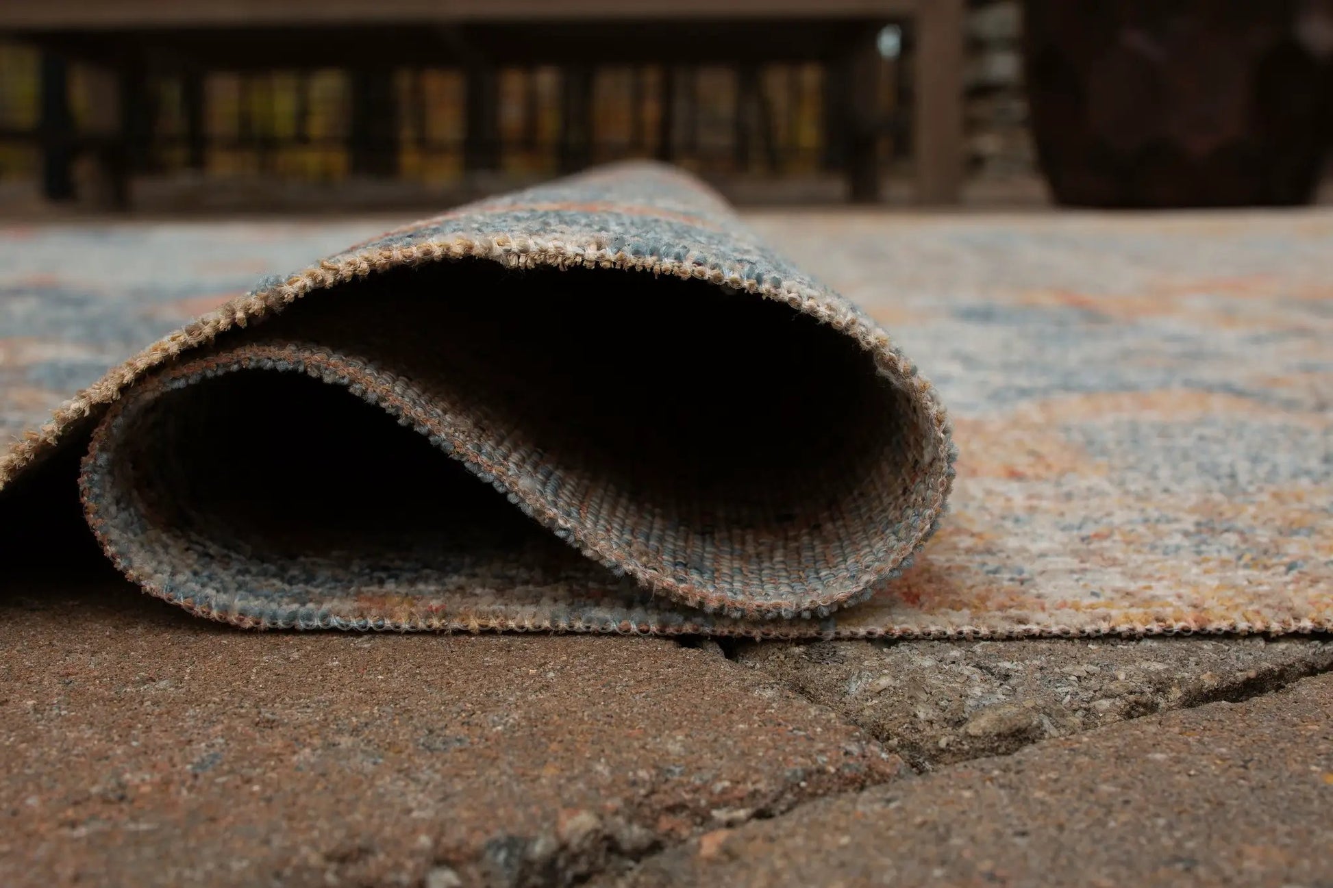 Wraylen rug, blue-gray woven indoor/outdoor rug rolled on a textured surface on Tampa Home & Garden Store