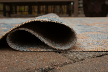 Wraylen rug, blue-gray woven indoor/outdoor rug rolled on a textured surface on Tampa Home & Garden Store