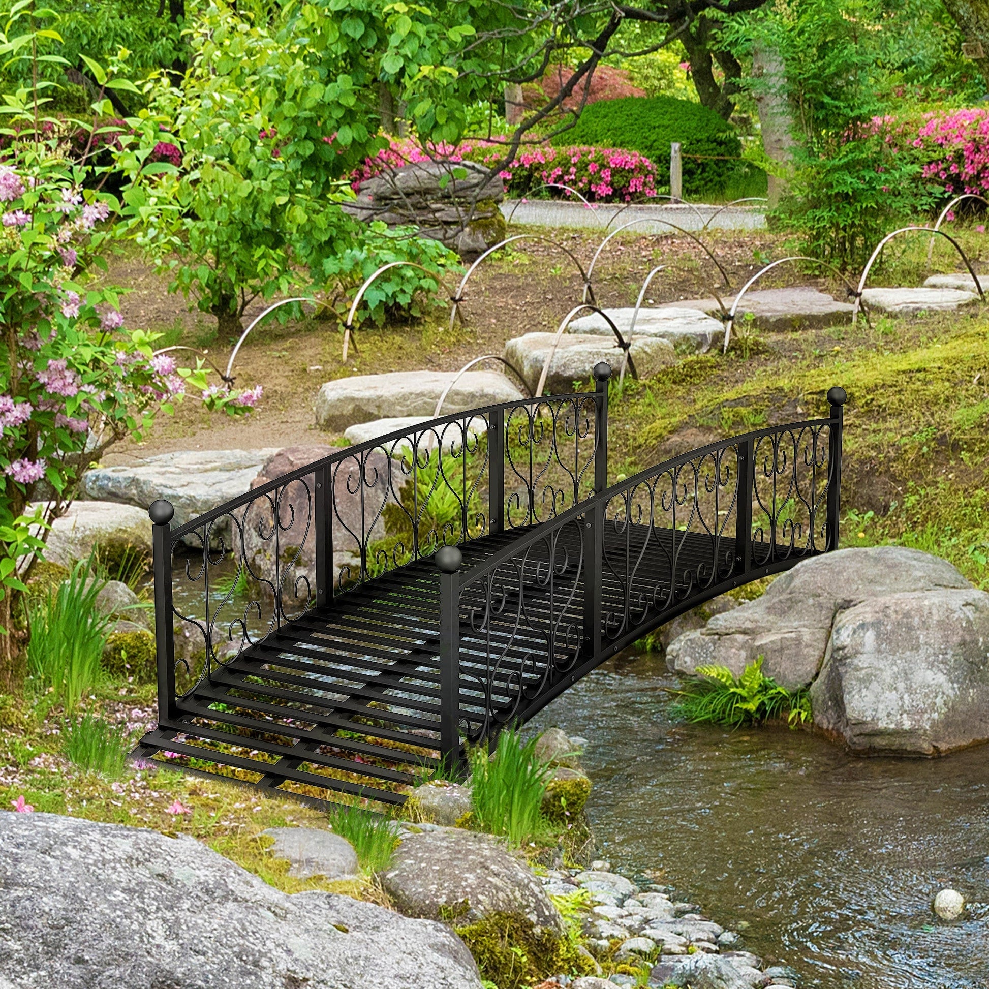 Outsunny 7' metal arch garden bridge with safety siderails over a stream in a lush garden on Tampa Home & Garden Store