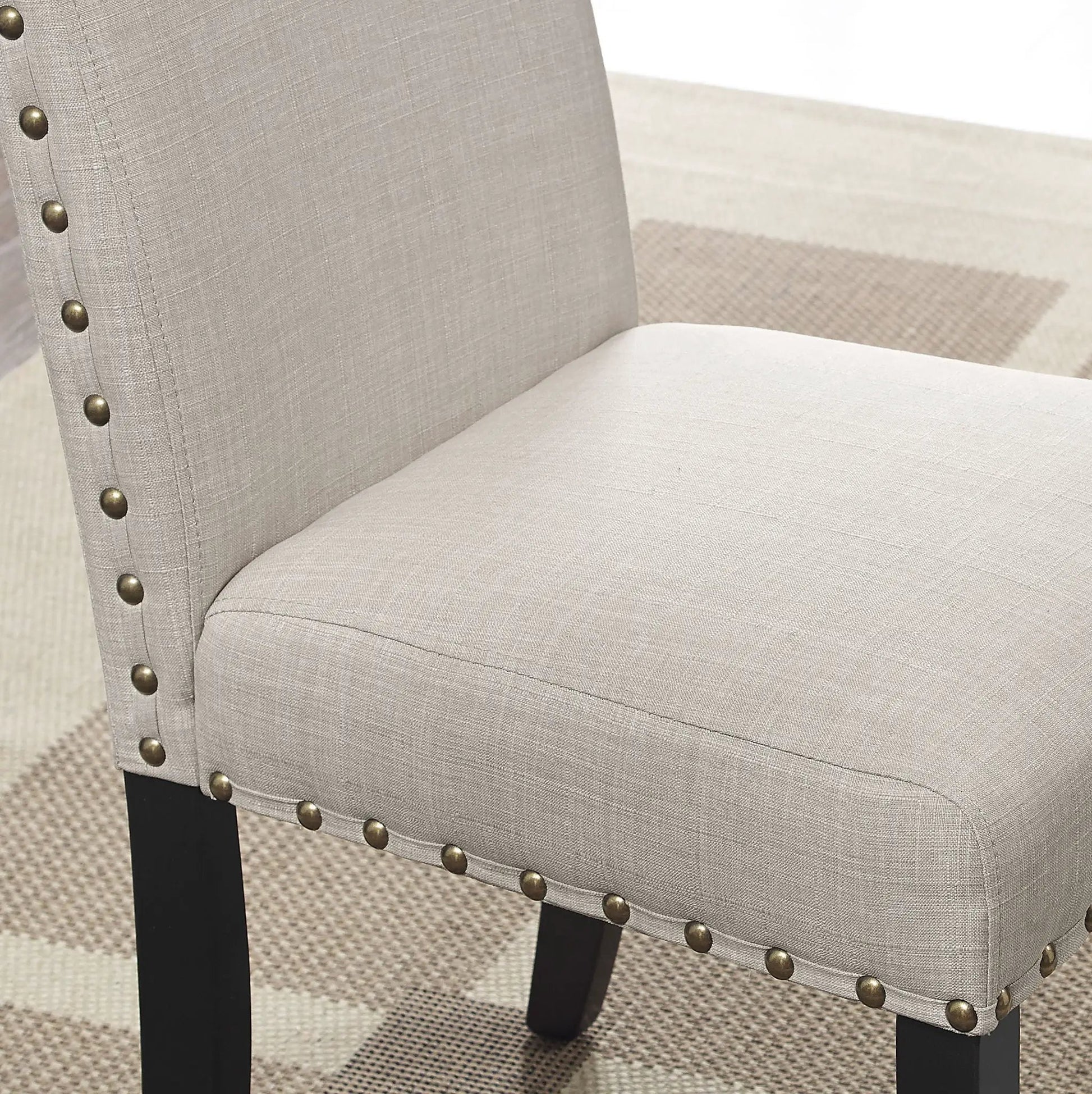 Mytzi 5 Piece Dining Set tan upholstery chair close-up with nailhead trim and black legs on Tampa Home & Garden Store
