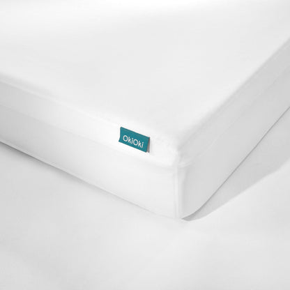 OkiOki King mattress protector in white fabric with teal tag on edge on Tampa Home & Garden Store