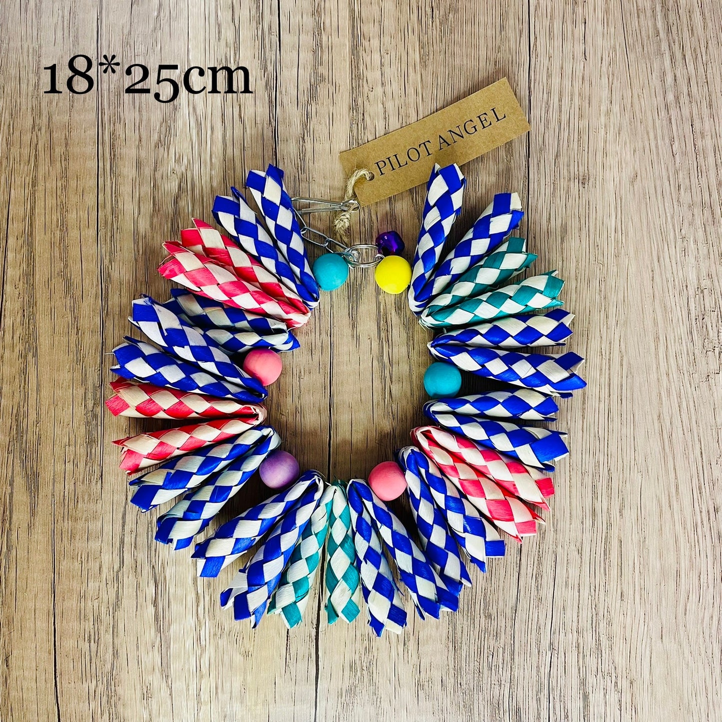 Parrot woodskin hand-woven toy circle with blue red teal braids and beads on wood background on Tampa Home & Garden Store