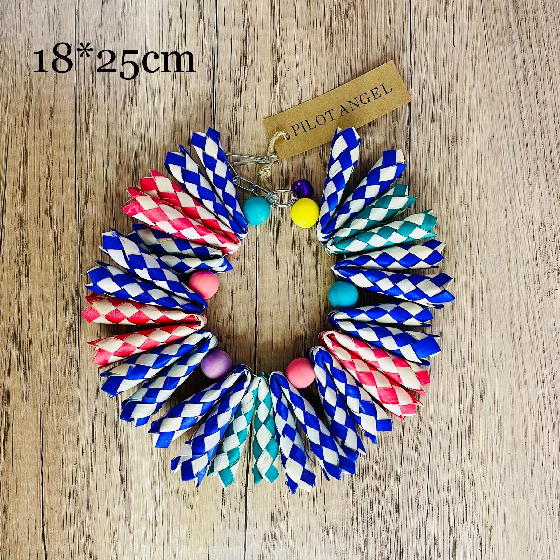 Parrot woodskin hand-woven toy circle with blue red teal braids and beads on wood background on Tampa Home & Garden Store