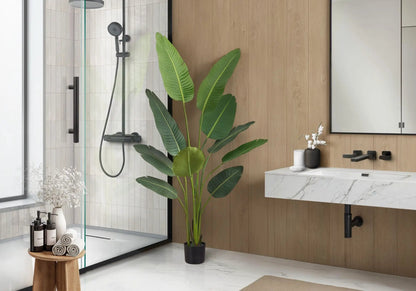 Bird of Paradise artificial plant in a black pot beside a marble bathroom vanity on Tampa Home & Garden Store