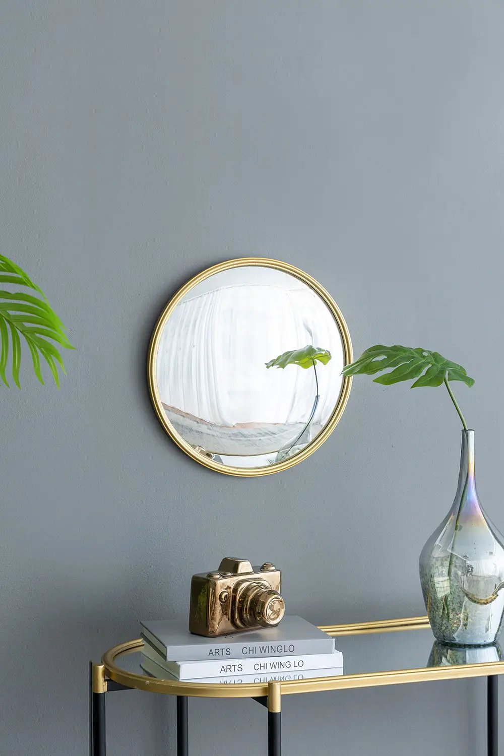 Round wall mirror with gold iron frame on gray wall on Tampa Home & Garden Store