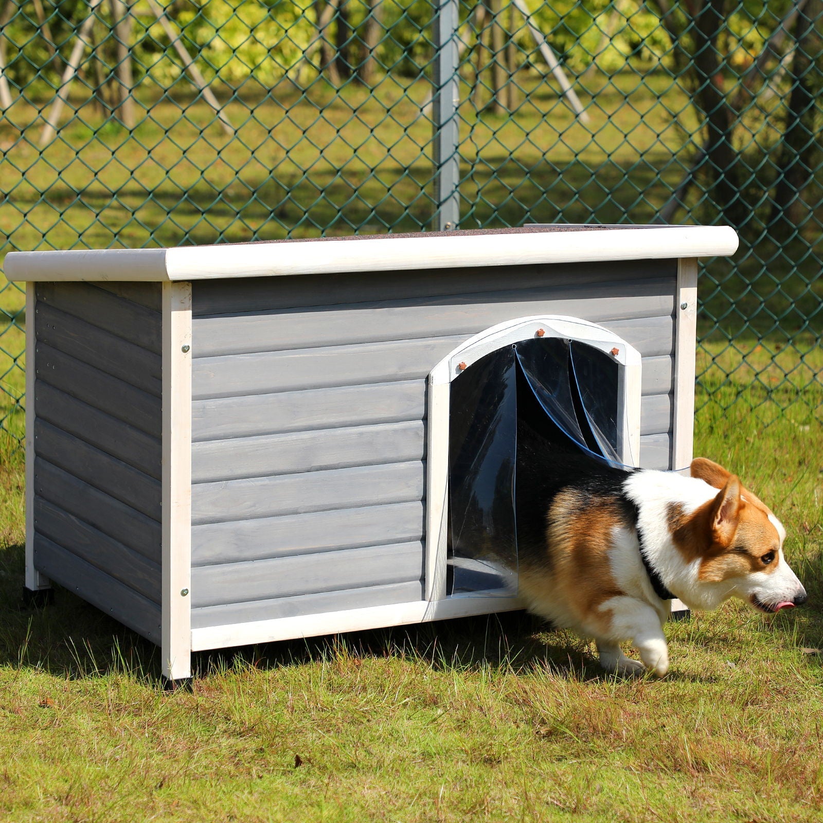 Medium wooden outdoor dog house in gray with white trim and elevated base; dog at doorway on lawn on Tampa Home & Garden Store