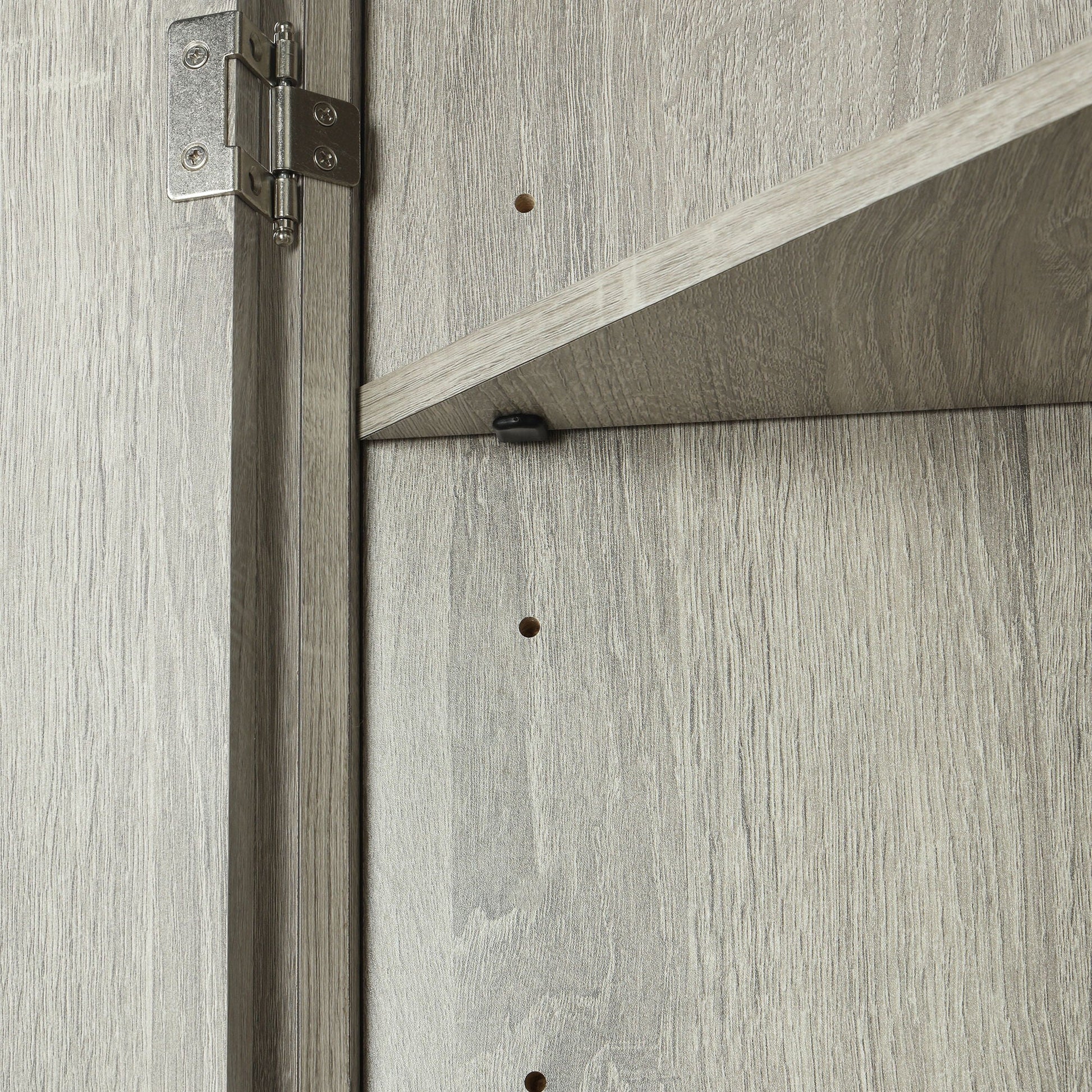 Linen cabinet door hinge close-up on gray wood grain panel with exposed screws on Tampa Home & Garden Store
